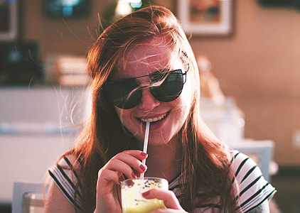 woman zipping drink while smiling thumbnail