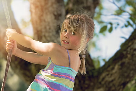 selective focus of girl holding rope near tree thumbnail