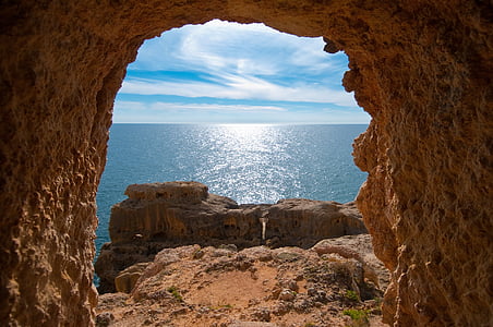 photo of brown cave near body of water thumbnail