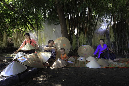 three woman and baby sitting under bamboo trees thumbnail