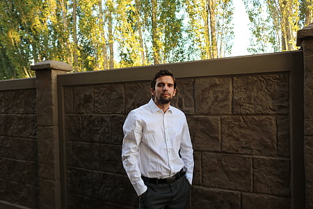 man wearing white dress shirt and black dress pants near beige wall thumbnail