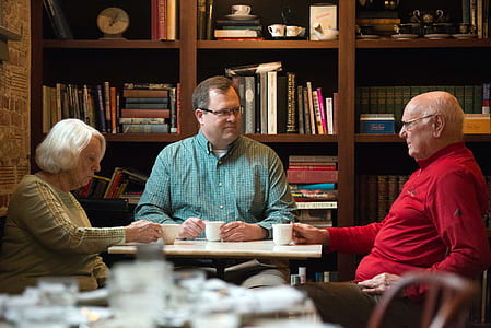 two men and woman sitting in front of table thumbnail