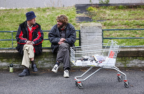 two men sitting on bench near white shopping cart thumbnail