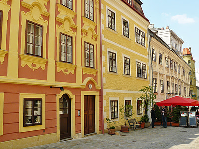 red canopy infront of orange and yellow painted house thumbnail