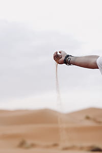 selective focus photography of person holding sand thumbnail