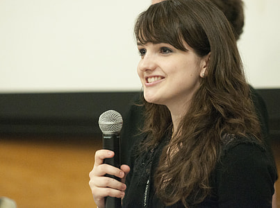 woman wearing black jacket holding black dynamic microphone thumbnail