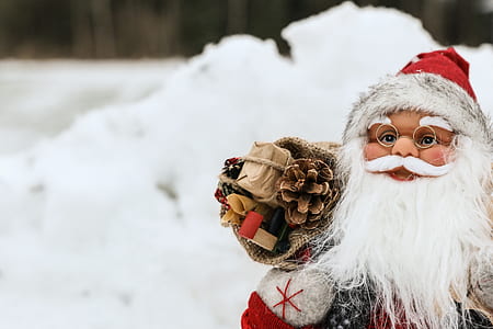 selective focus photography of Santa Claus carrying bag of gifts figurine thumbnail