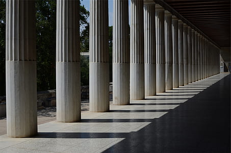 white concrete columns near green leafed trees thumbnail