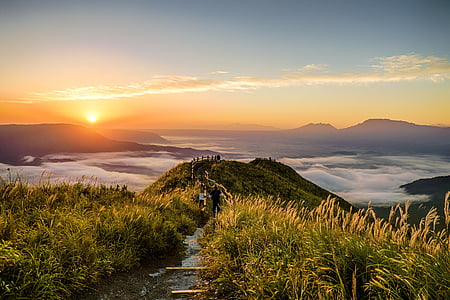 pathway between grass leading to a mountain top with an overview of sea of clouds during sunset thumbnail