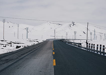 black concrete road near snow covered mountain thumbnail