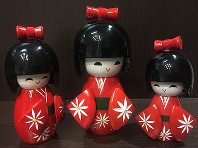 three nesting dolls on black wooden table thumbnail