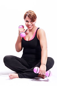 woman in black tank top sitting on floor while holding pink shaker dumbbells thumbnail