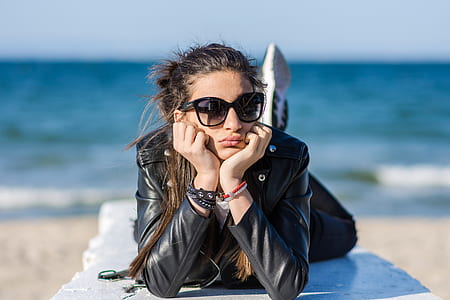 woman laying on white platform near shoreline thumbnail