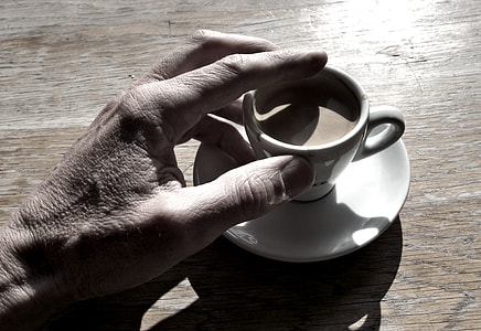 person touching white cup on saucer thumbnail