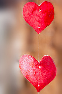 photography of two red heart shaped paper cutout hanging decor thumbnail