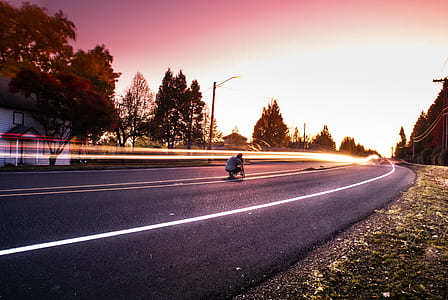 Person Sitting on Black Top Road during Twilight thumbnail