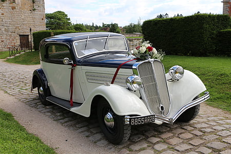white and blue vehicle parked on brown bricked road thumbnail
