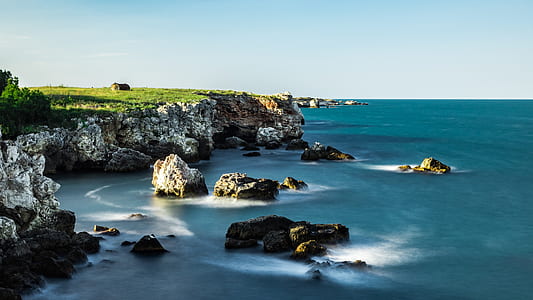 cliff over body of water during daytime thumbnail