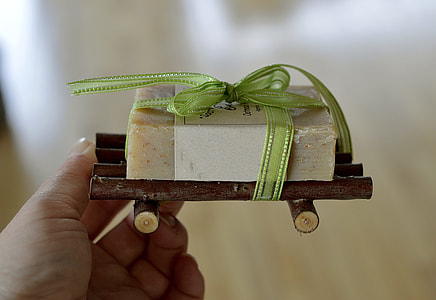person holding white soap bar on brown raft thumbnail