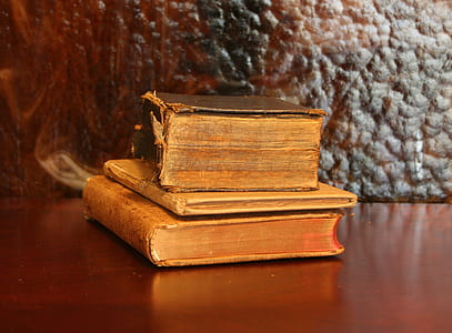 three brown hardbound books thumbnail