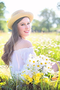 selective focus photography of woman sitting on grass surrounded by grass and white daisy flowers during daytime thumbnail