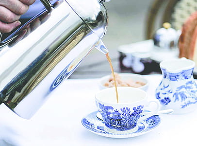 person pouring tea on ceramic teacup thumbnail