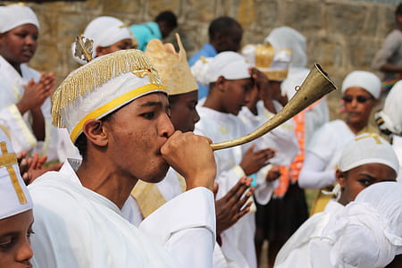 person in white top holding horn in focus photography thumbnail