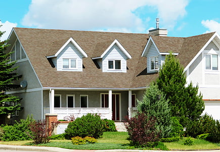 white and brown house with green trees and bushes thumbnail