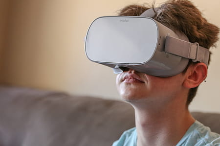 Teenage boy sitting indoors, wearing virtual reality headset thumbnail