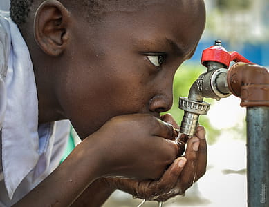 Boy Drinking Water on Faucet thumbnail