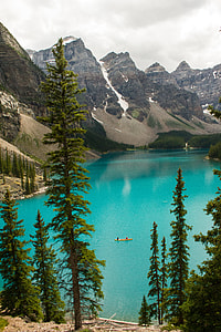 two person riding on brown boat in the middle of banff canada lake thumbnail