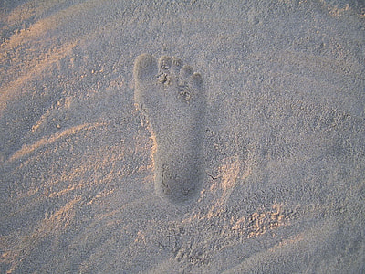 person foot mark on sand during daytime thumbnail