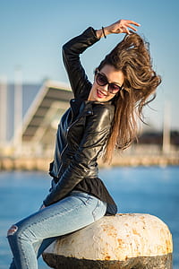 woman sitting on concrete beside sea thumbnail