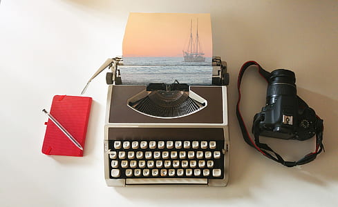 black DSLR camera and white typewriter thumbnail