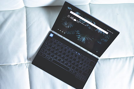black laptop computer on white sofa thumbnail