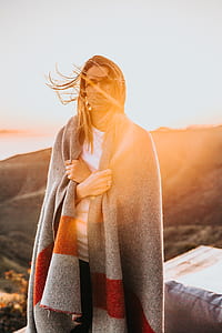 woman in gray and red blanket during sunset thumbnail