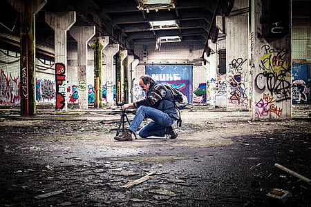 man wearing jacket and jeans holding camera stand inside the tunnel thumbnail