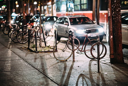 black road bike parked beside gray sedan thumbnail