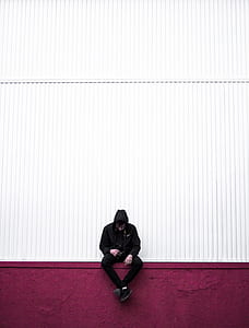 man wearing hoodie and jeans sitting thumbnail