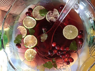 punch bowl filled with juice and fruit slices thumbnail
