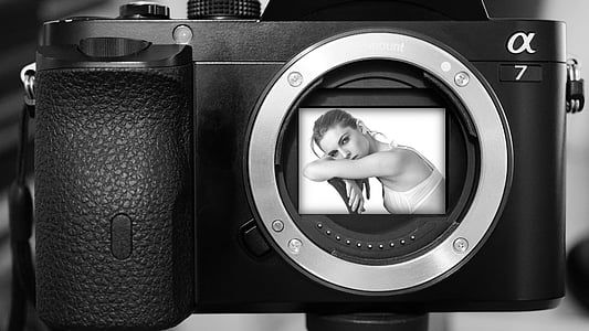 grayscale photo of woman leaning on chair inside DSLR camera thumbnail