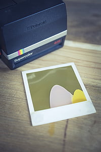 black Polaroid Supercolor instant camera on brown wooden surface thumbnail
