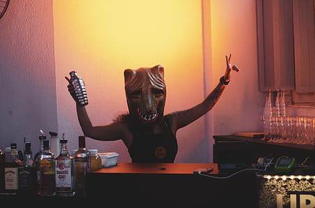 Person Wearing Mask Holding Cocktail Shaker thumbnail