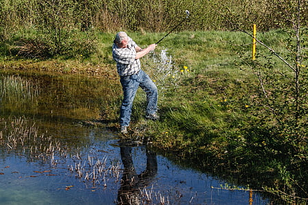 man standing on green grass near body of water thumbnail