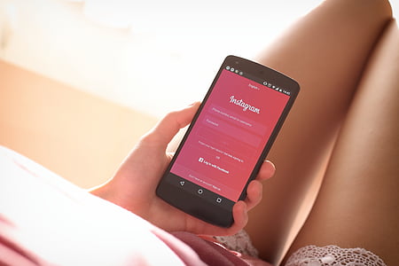 woman holding black LG Nexus 5 smartphone thumbnail