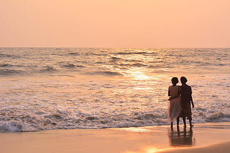 two persons staring at body of water during sunset thumbnail