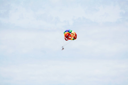 person doing paragliding under cloudy sky thumbnail