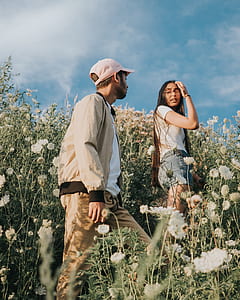 couple walking through white petaled flowers during daytime thumbnail