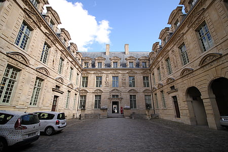 two white vehicles parked in front of brown building thumbnail