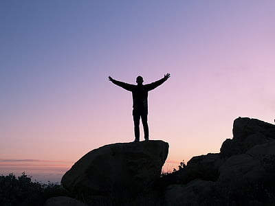 silhouette of person standing on rock thumbnail